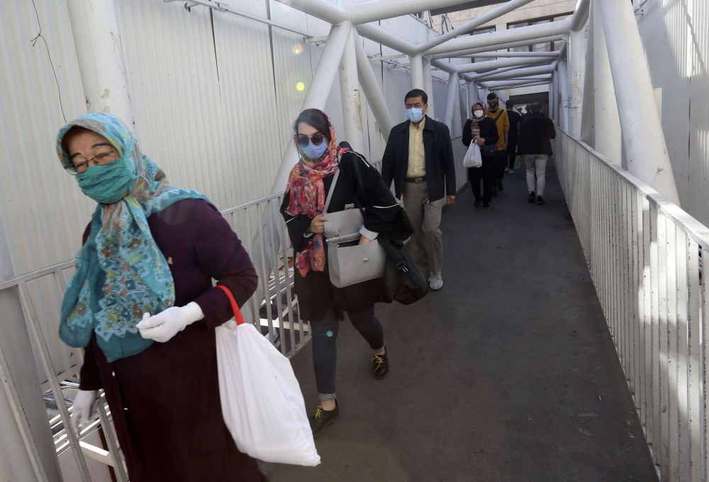 Mask-clad Iranians walk along an overpass on their way to shop in Tajrish square in the capital Tehran on November 1, 2020, amid the novel coronavirus pandemic crisis. AFP / ATTA KENARE