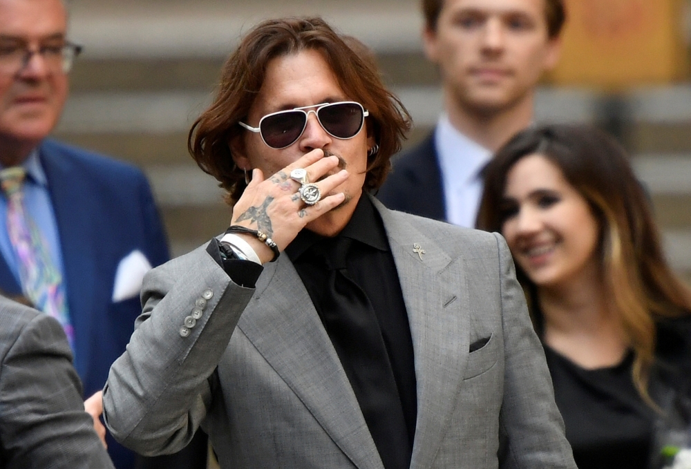FILE PHOTO: Actor Johnny Depp gestures as he leaves the High Court in London, Britain July 28, 2020. REUTERS/Toby Melville/File Photo