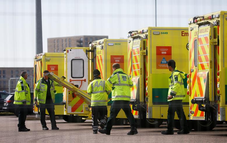 FILE PHOTO: Paramedics and ambulances are seen outside the Excel Centre, London while it is being prepared to become the NHS Nightingale Hospital, as the spread of the coronavirus disease (COVID-19) continues, London, Britain, April 1, 2020. REUTERS/Henry