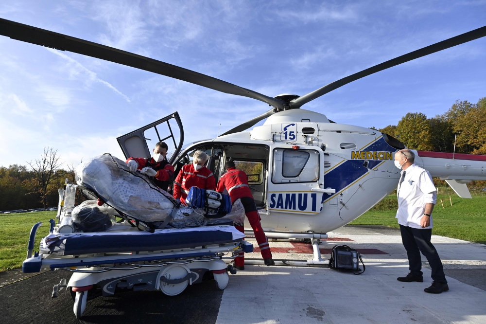 Medics carry a patient infected with Covid-19 into a helicopter as he is transferred from the university hospital in Liege to Koln, Germany, on November 3, 2020. AFP / BELGA / ERIC LALMAND