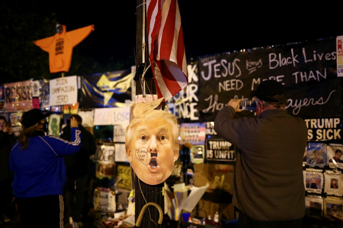 A mask depicting U.S President Donald Trump is seen as Supporters of U.S. Democratic presidential nominee Joe Biden gather near the White House during Election Day in Washington, U.S., November 3, 2020. REUTERS/Hannah McKay
