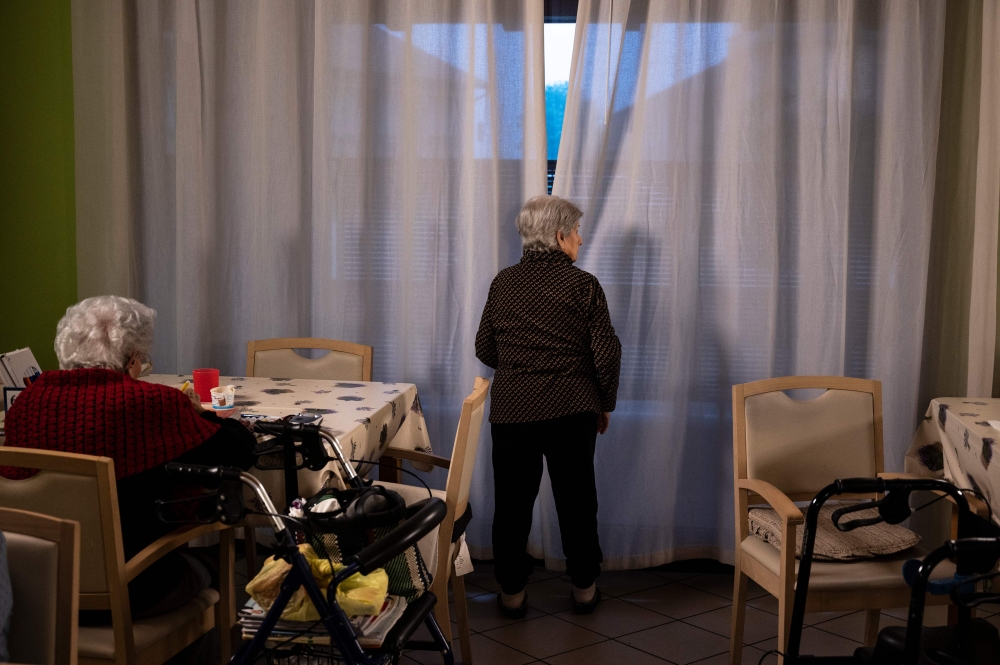 Elderly residents gather in a common area at the 'Torre della Rocchetta' retirement home in Albuzzano, near Pavia, Northern Italy, on November 3, 2020. / AFP / Marco Bertorello