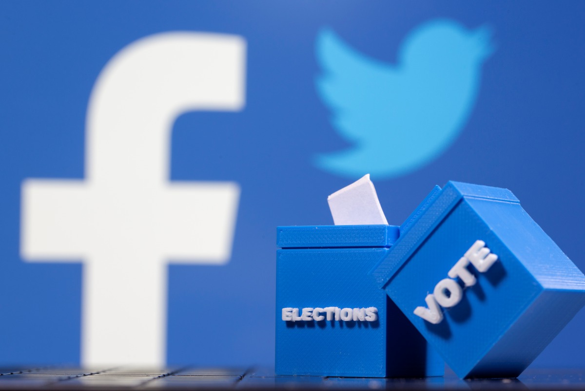 3D printed ballot boxes are seen in front of displayed Facebook and Twitter logos in this illustration taken November 4, 2020. REUTERS/Dado Ruvic/Illustration
