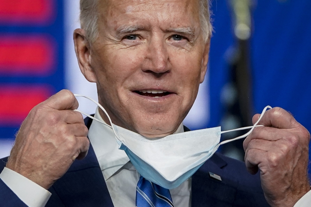 Democratic presidential nominee Joe Biden takes his face mask off as he arrives to speak one day after America voted in the presidential election, on November 04, 2020 in Wilmington, Delaware. Biden spoke as votes are still being counted in his tight race