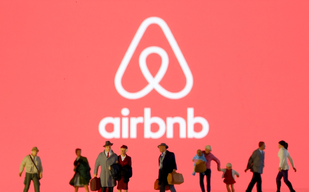 Small toy figures are seen in front of diplayed Airbnb logo in this illustration taken March 19, 2020. REUTERS/Dado Ruvic/Illustration/File Photo