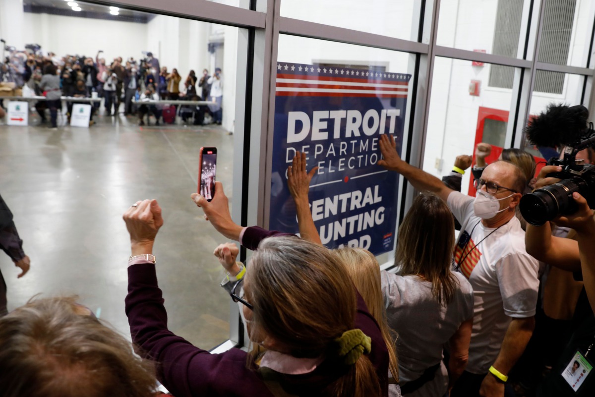TOPSHOT - Supporters of US President Donald Trump bang on the glass and chant slogans outside the room where absentee ballots for the 2020 general election are being counted at TCF Center on November 4, 2020 in Detroit, Michigan. Democratic presidential c