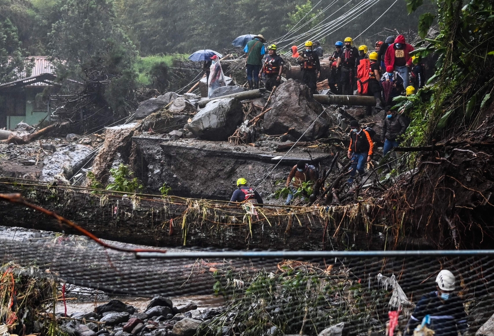 Members of Red Cross help to evacuate people after the overflow of Bambito river due to the heavy rains caused by Hurricane Eta, now degraded to a tropical storm, in Bambito, Chiriqui Province 450 north of Panama City, on November 05, 2020. / AFP / Luis A