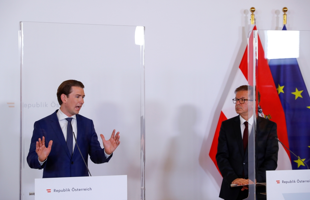 Austria's Health Minister Rudolf Anschober listens as Chancellor Sebastian Kurz speaks during a news conference, as the spread of the coronavirus disease (COVID-19) continues, in Vienna, Austria October 31, 2020. REUTERS/Leonhard Foeger