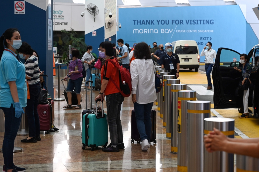 Passengers arrive at the departure area at Marina Bay Cruise Centre in Singapore on November 6, 2020 for 
