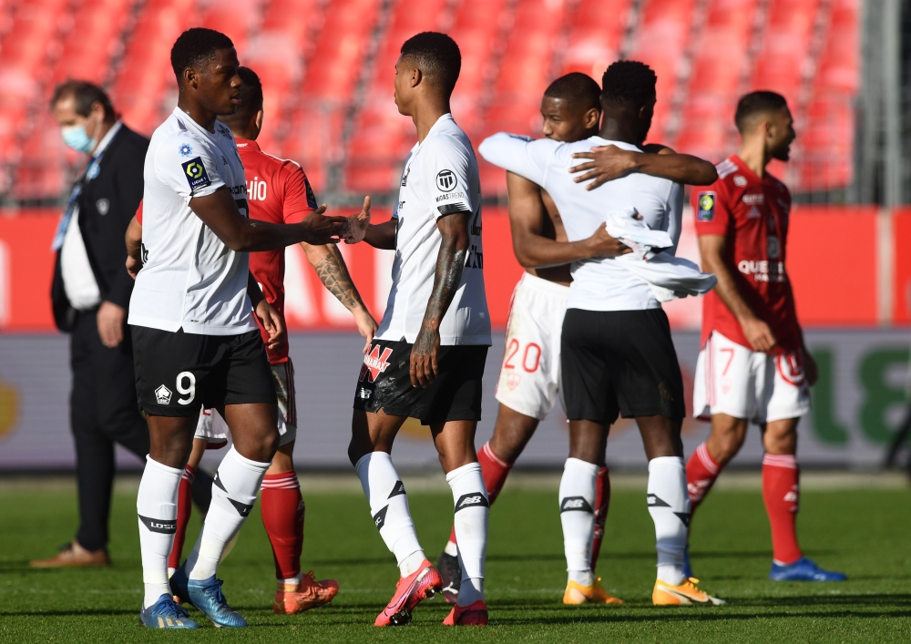 Brest's players and Lille's players congratulate at the end of the French L1 football match between Brest and Lille at the Francis Le Ble Stadium in Brest on November 8, 2020. / AFP / Fred TANNEAU