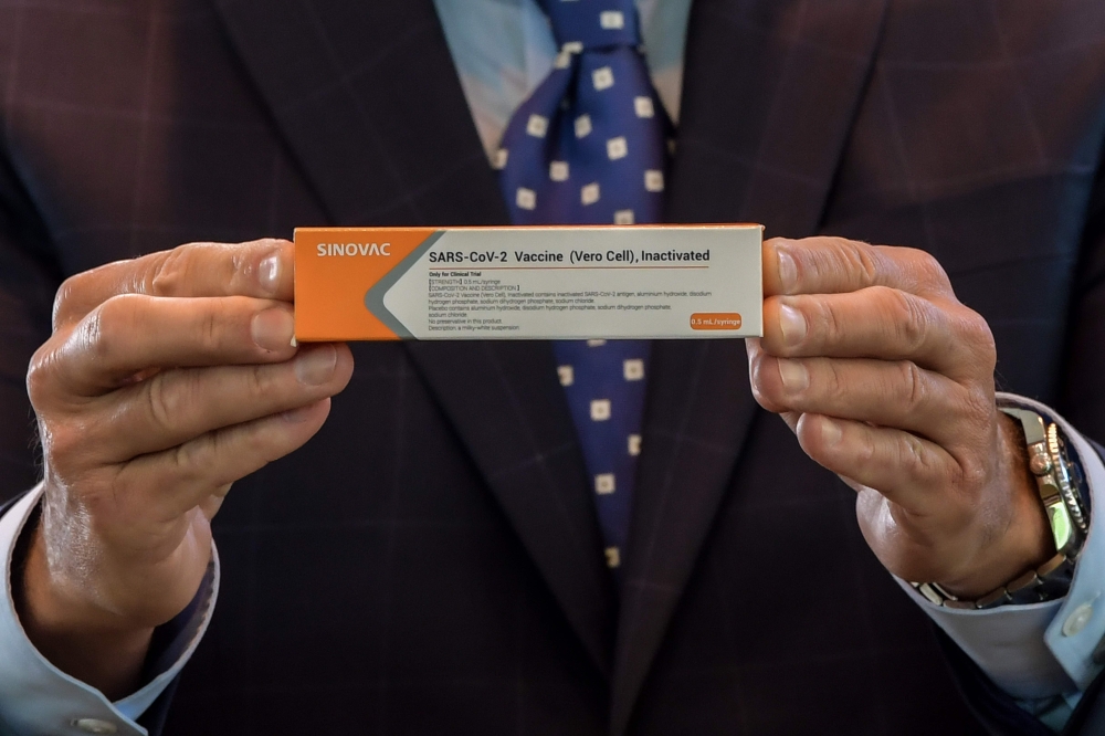 In this file photo taken on July 21, 2020 Sao Paulo State Governor Joao Doria displays a box of the COVID-19 vaccine produced by the Chinese company Sinovac Biotech at the Hospital das Clinicas (HC) in Sao Paulo State, during its trial stage, during a pre