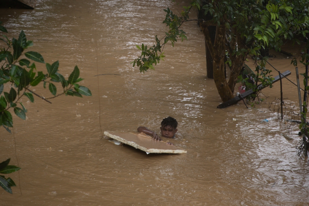 Boy holds onto styrofoam as he wades through neck-deep flood caused by Typhoon Vamco, in Marikina, Metro Manila, Philippines, November 12, 2020. REUTERS/Eloisa Lopez