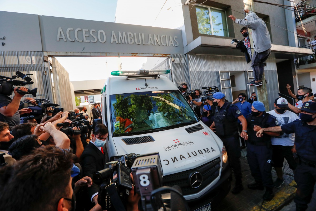 An ambulance carrying Argentine soccer great Diego Maradona leaves the clinic where Maradona underwent brain surgery, in Olivos, on the outskirts of Buenos Aires, Argentina November 11, 2020. REUTERS/Agustin Marcarian
