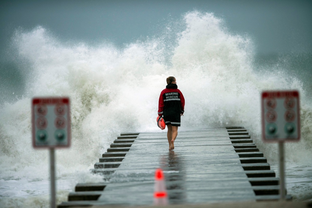 A lifeguard walks to the end of the jetty after closing it down to surfers before the arrival of Tropical Storm Eta in Bradenton Beach, Florida, U.S. November 11, 2020. REUTERS/Steve Nesius
