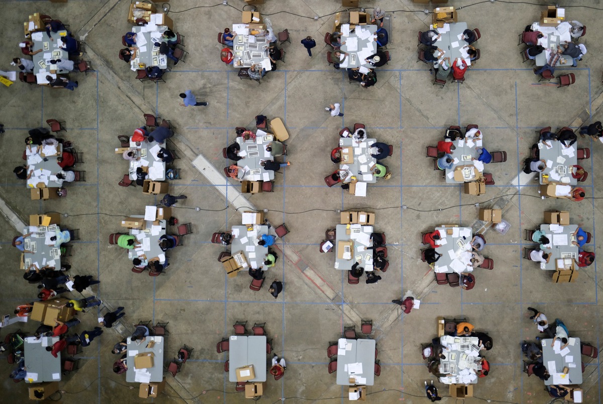 Electoral workers count votes from briefcases with uncounted ballots for the election of local leaders in a tabulation center at the Roberto Clemente Coliseum in San Juan, Puerto Rico, November 11, 2020. Officials said over 180 briefcases were discovered 