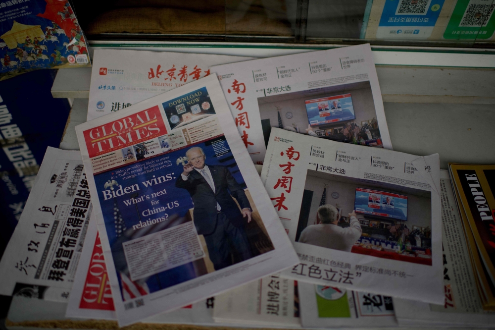 Newspaper front pages lead with the victory of Joe Biden in the US presidential election, at a news stand in Beijing on November 9, 2020. / AFP / Noel Celis
