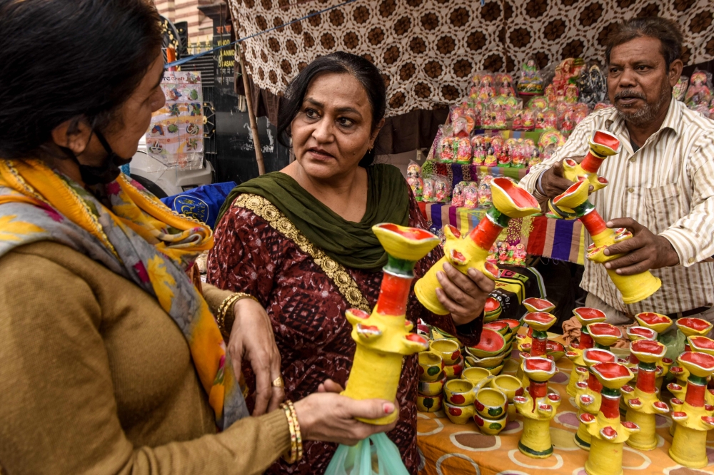 People buy lamps for Diwali, the Hindu festival of lights, on a street in Amritsar on November 14, 2020. / AFP / NARINDER NANU