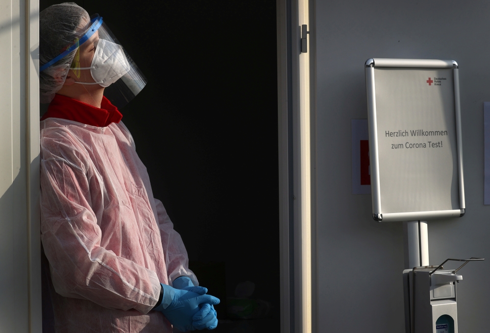 A member of Germany's Red Cross medical staff waits for people at a newly installed drive- and walk-in corona test centre as the spread of the coronavirus disease (COVID-19) continues in Frankfurt, Germany, November 13, 2020. REUTERS/Kai Pfaffenbach/File 