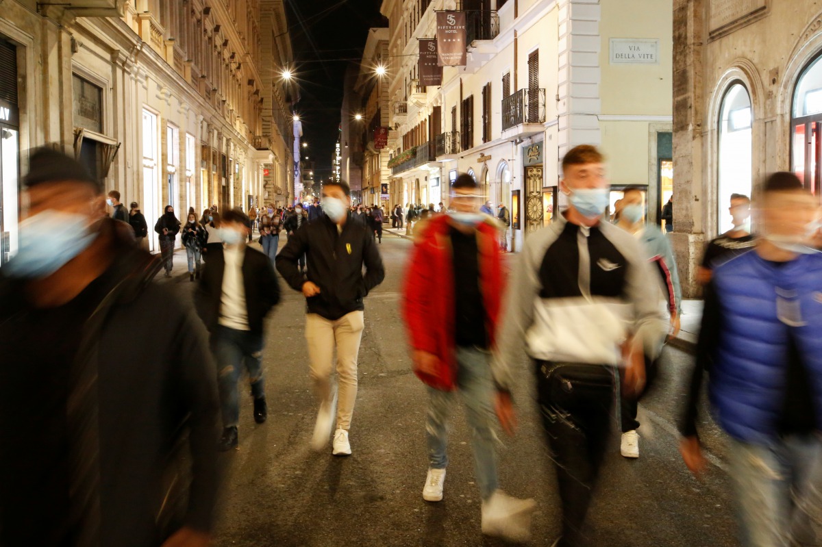 People wearing protective masks walk along the principal shopping street of Via del Corso, as the number of people infected by the coronavirus disease (COVID-19) continues to rise, in Rome, Italy, November 14, 2020. REUTERS/Remo Casilli
