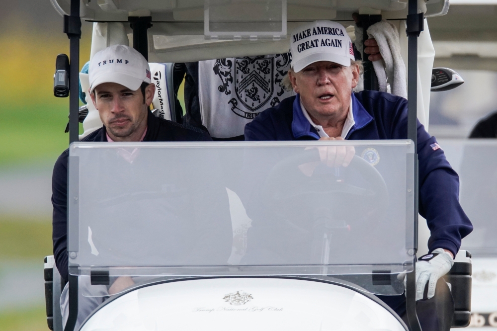 U.S. President Donald Trump drives a golf cart at the Trump National Golf Club in Sterling, Virginia, U.S., November 15, 2020. REUTERS/Joshua Roberts