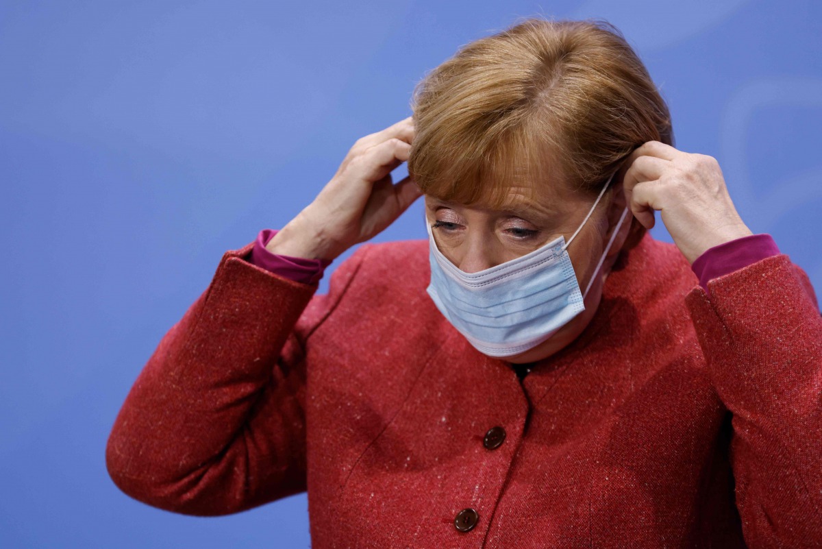 German Chancellor Angela Merkel puts on her face mask before leaving after a news conference on the coronavirus following video consultations with the premiers of Germany's 16 federal states at Chancellery in Berlin on November 16, 2020. / AFP / POOL / Od