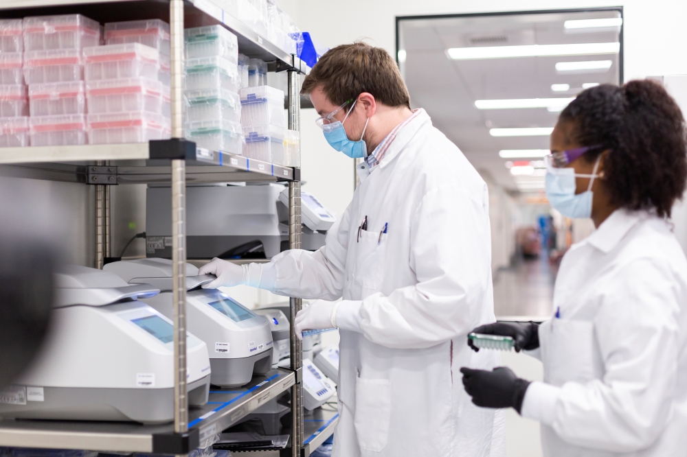 Researchers work in a lab run by Moderna Inc, who said November 16, 2020 that its experimental vaccine was 94.5% effective in preventing COVID-19 based on interim data from a late-stage clinical trial, in an undated photograph. Moderna Inc/Handout via REU