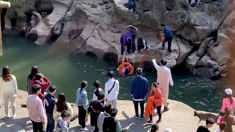 Stephen Ellison, British consul-general in Chongqing, rescues a drowning student, who had fallen into a river by accident, at a scenic spot in Chongqing, China November 14, 2020, in this screengrab taken from video. Jiang Lang via British consulate in Cho