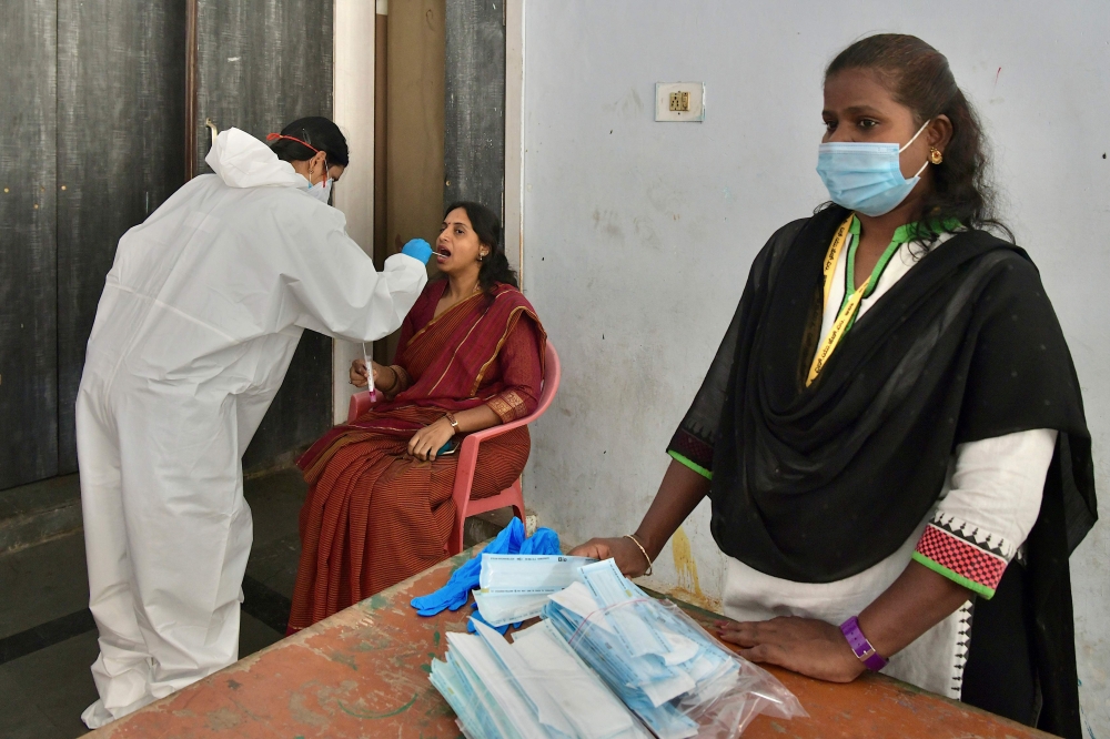 A health worker conducts a rapid antigen test for Covid-19 coronavirus on a lecturer at college premises as the state government education department directed the reopening of degree colleges after several months of closure in wake of the coronavirus pand