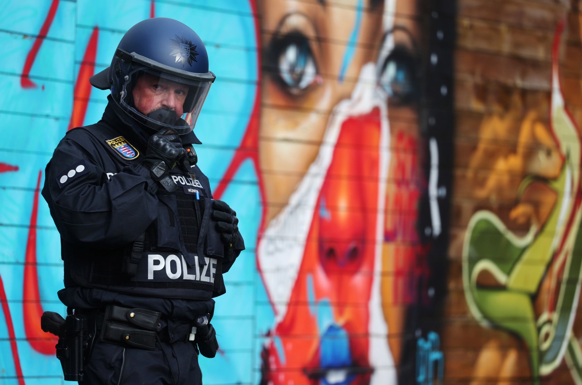 A police officer prepares before protest against the government's restrictions, amid the coronavirus disease (COVID-19) outbreak, in Frankfurt, Germany, November 14, 2020. REUTERS/Kai Pfaffenbach
