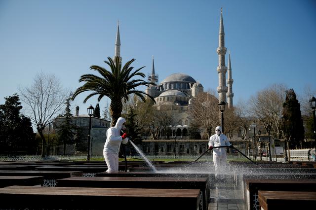 FILE PHOTO: Workers in protective suits disinfect the park in front of the Blue Mosque in response to the spread of coronavirus disease (COVID-19) in Istanbul,Turkey March 21, 2020. REUTERS/Kemal Aslan
