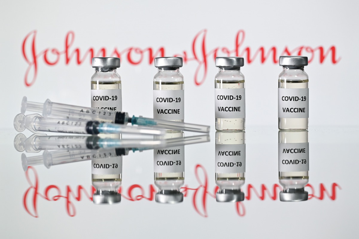 An illustration picture shows vials with Covid-19 Vaccine stickers attached and syringes with the logo of US pharmaceutical company Johnson & Johnson on November 17, 2020. / AFP / JUSTIN TALLIS
