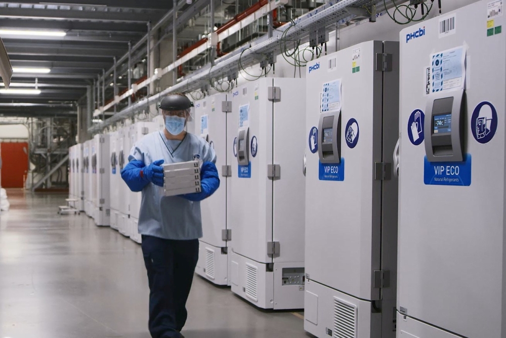 A worker passes a line of freezers holding coronavirus disease (COVID-19) vaccine candidate BNT162b2 at a Pfizer facility in Puurs, Belgium in an undated photograph. Pfizer/Handout via Reuters