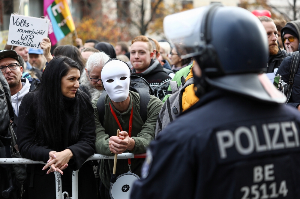 A demonstrator wears a white mask during a protest against the government's coronavirus disease (COVID-19) restrictions, near the Reichstag, the seat of Germany's lower house of parliament Bundestag, in Berlin, November, 18, 2020. Reuters/Christian Mang