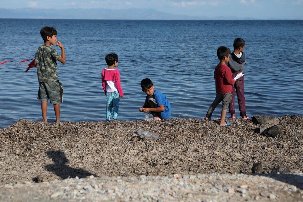 FILE PHOTO: Children stand next to the sea at the Kara Tepe camp for refugees and migrants on the island of Lesbos, Greece, October 14, 2020. REUTERS/Elias Marcou