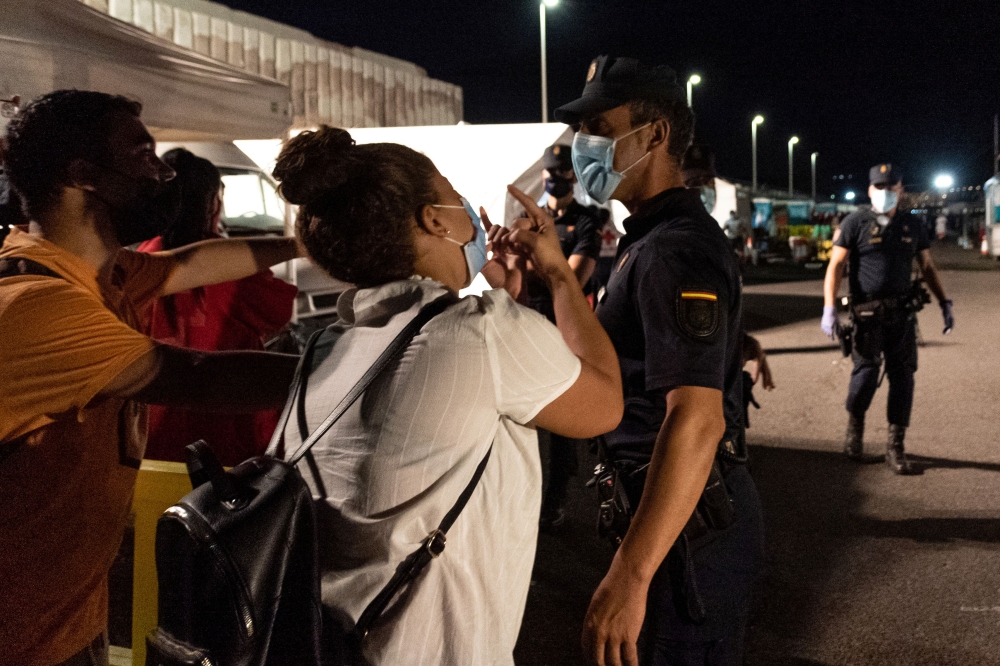 Sarah Bettache requests a Spanish National Police officer to help her find her brother Ahmed, a 19-year-old migrant from Morocco, in the port of Arguineguin, Gran Canaria, Spain November 16, 2020. REUTERS/Eduardo Robaina/La Marea