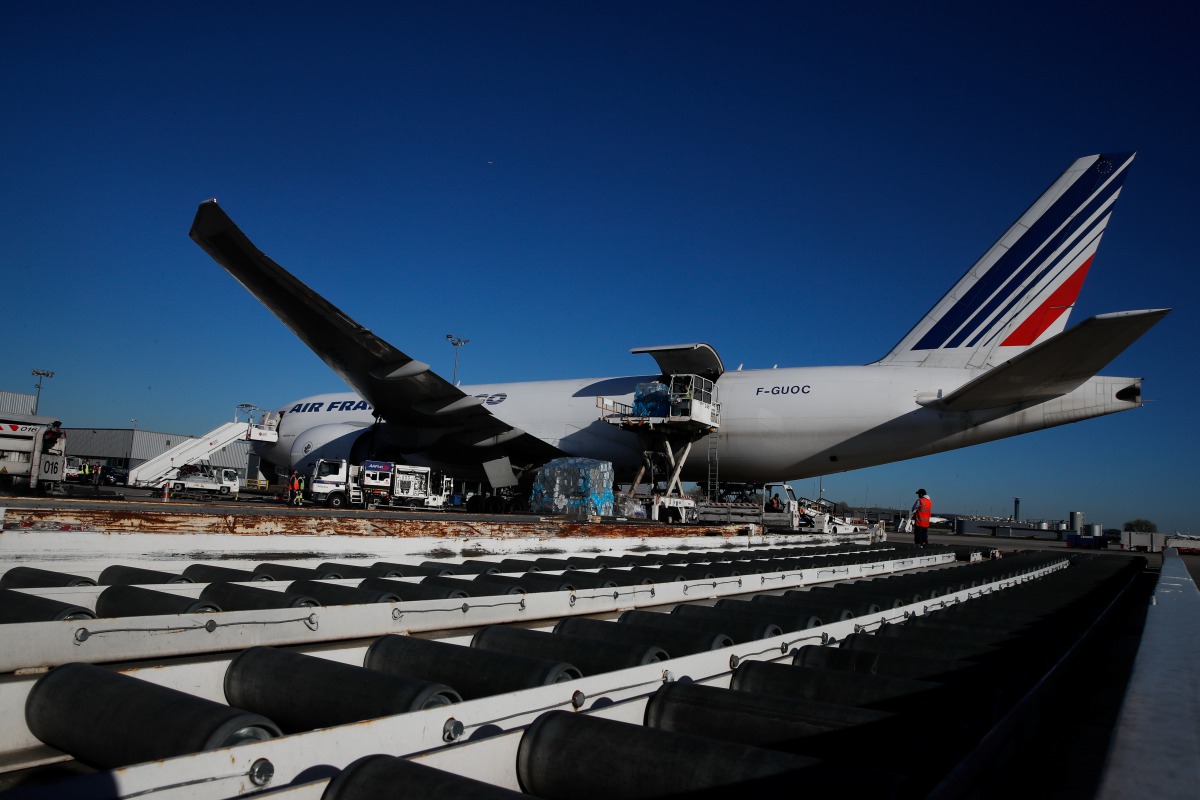 Air France employees load a Boeing 777 cargo plane with Active Temperature Control containers carrying rabies vaccines at Charles de Gaulle airport in Roissy, near Paris as the coronavirus disease (COVID-19) outbreak continues in France November 18, 2020.