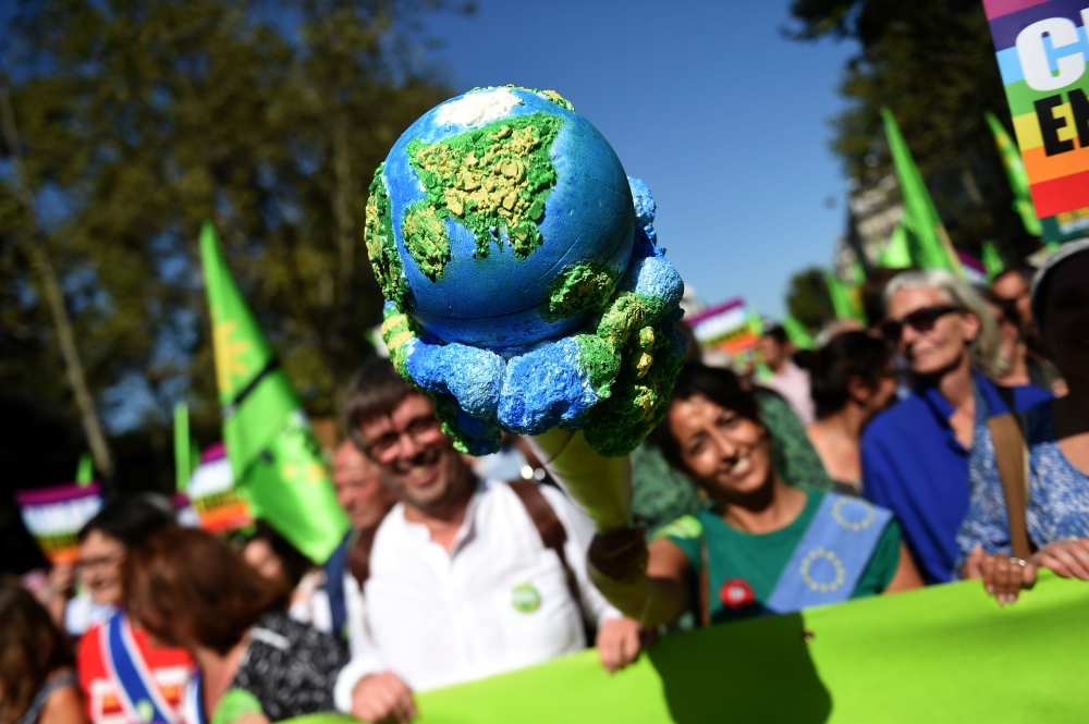 (FILES) In this file photograph taken on September 21, 2019, Europe Ecologie Les Verts (EELV) Green Party deputy and Mayor of Grande-Synthe Damien Careme (C) and Europe Ecologie Les Verts (EELV) European MP Karima (in green with the giant ice cream) march