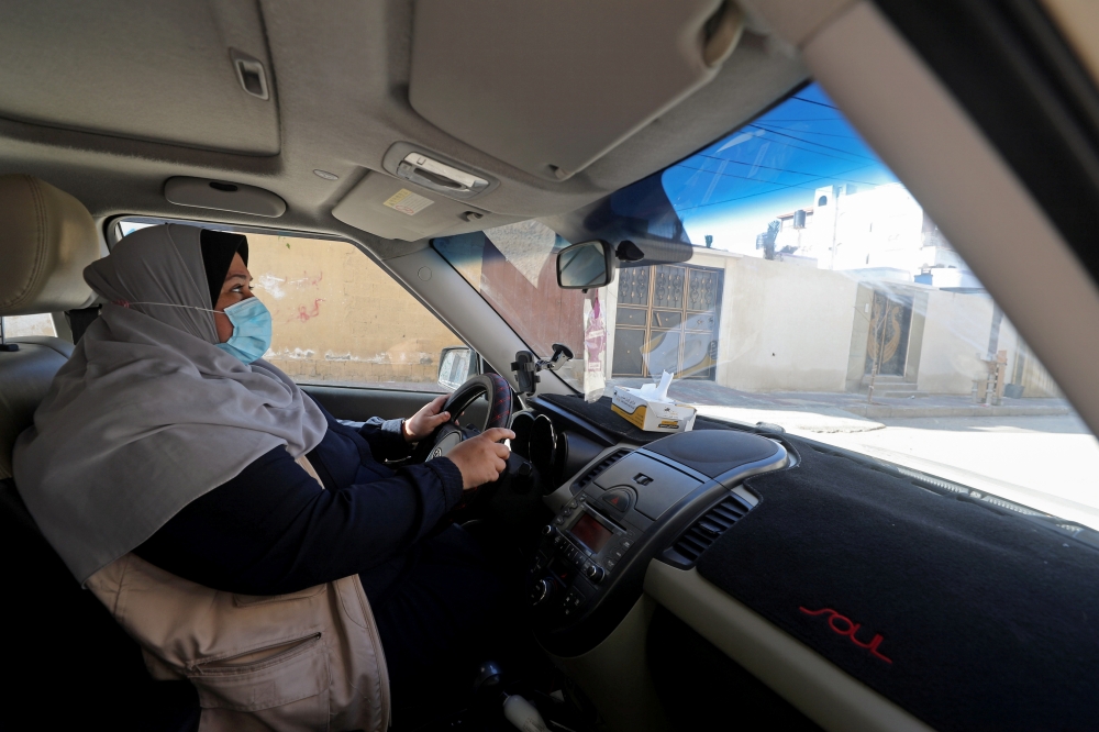 Palestinian woman Naela Abu Jibba, who started a women-only taxi service in Gaza Strip, drives her vehicle at Beach refugee camp in Gaza City November 17, 2020. Picture taken November 17, 2020. REUTERS/Mohammed Salem