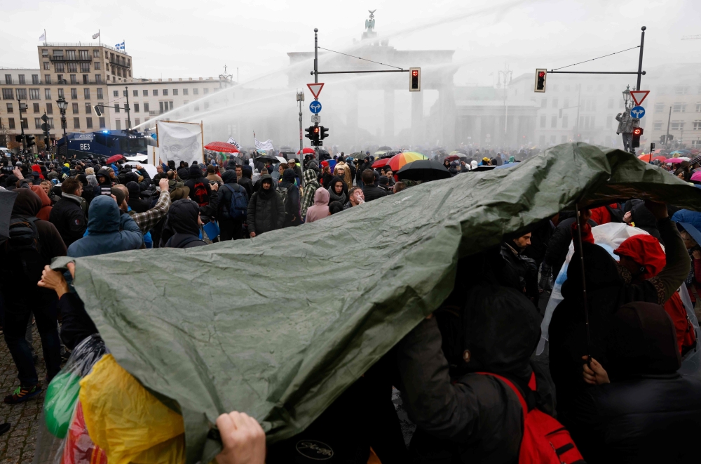 Police use a water cannon to disperse protesters demonstrating against measures imposed by the German government to limit the spread of the novel coronavirus, on November 18, 2020 close to the Brandenburg Gate in Berlin.  AFP / Odd ANDERSEN
