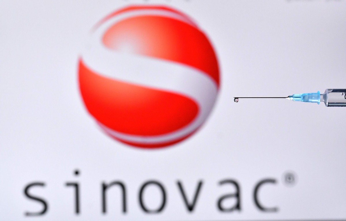 An illustration picture shows a drop from a syringe with the logo of Chinese biopharmaceutical company Sinovac on November 17, 2020. / AFP / JUSTIN TALLIS
