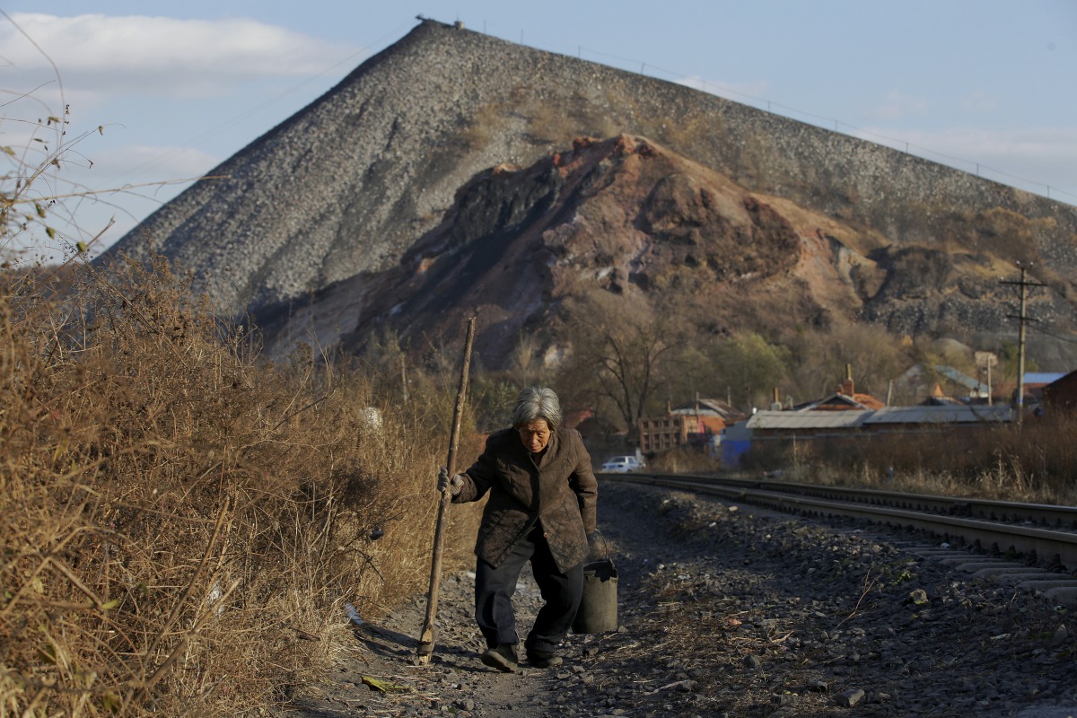FILE PHOTO: An elderly villager walks along a railway line on the outskirts of Jixi, in Heilongjiang province, China, October 24, 2015. REUTERS/Jason Lee/File Photo
