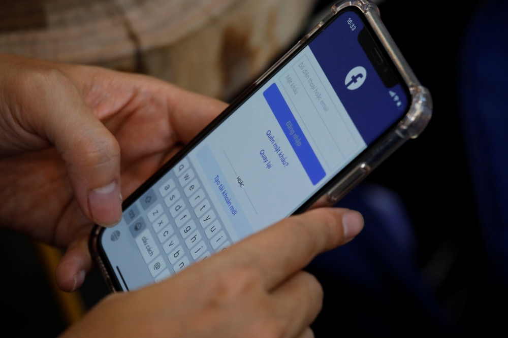 A Facebook user logs in on his mobile at a cafe in Hanoi, Vietnam November 19, 2020. REUTERS/Kham
