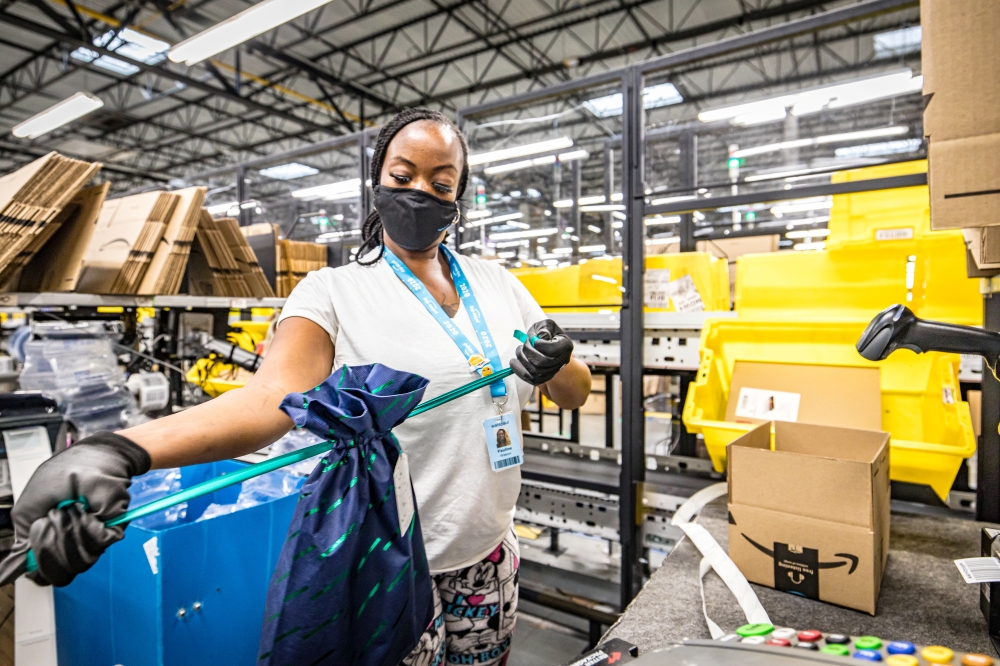 An Amazon.com Inc worker prepares an order in which the buyer asked for an item to be gift wrapped at a fulfillment center in Shakopee, Minnesota, U.S., November 12, 2020. Amazon.com Inc/Handout via Reuters