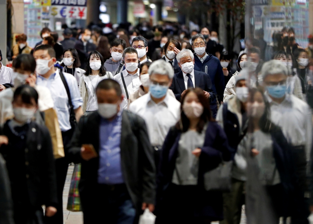 People wearing protective face masks walk on the street, amid the coronavirus disease (COVID-19) outbreak, in Tokyo, Japan November 19, 2020. REUTERS/Issei Kato/File Photo