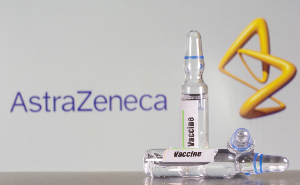 A test tube labeled with the vaccine is seen in front of AstraZeneca logo in this illustration taken, September 9, 2020. REUTERS/Dado Ruvic/File Photo