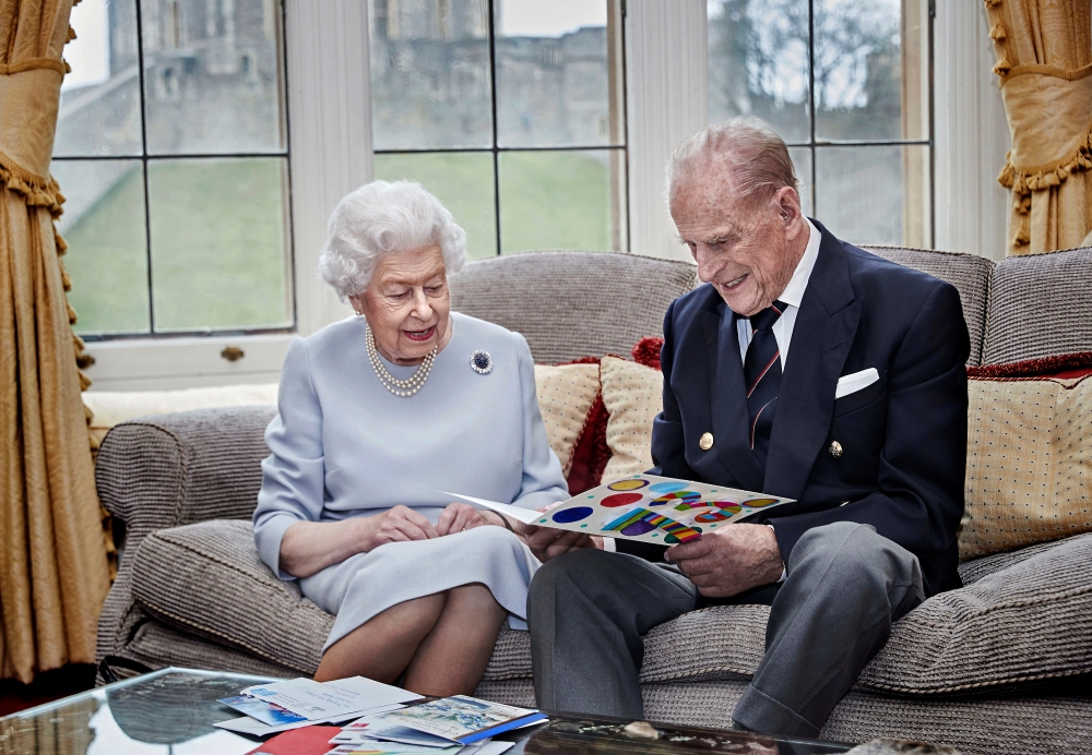 Britain's Queen Elizabeth and Prince Philip, Duke of Edinburgh look at their homemade wedding anniversary card, given to them by their great grandchildren Prince George, Princess Charlotte and Prince Louis, ahead of their 73rd wedding anniversary, in the 