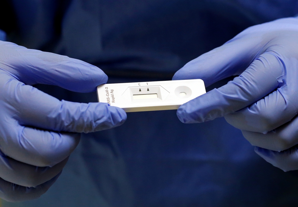 A staff member holds a rapid COVID-19 antigenic test made by Swiss drugmaker Roche, at the smear center of the University Hospital Zurich (USZ), as the spread of the coronavirus disease (COVID-19) continues, in Zurich, Switzerland November 19, 2020. Reute