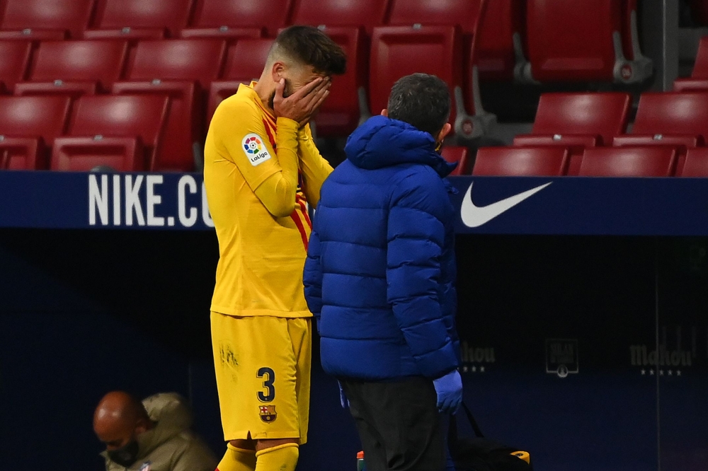 Barcelona's Spanish defender Gerard Pique (L) reacts as he walks off the pitch after getting injured during the Spanish League football match between Club Atletico de Madrid and FC Barcelona at the Wanda Metropolitano stadium in Madrid on November 21, 202