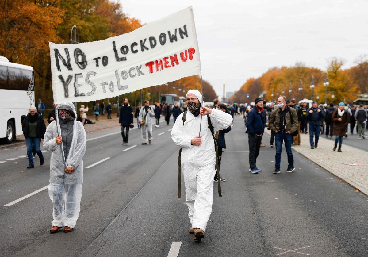 Two demonstrators walk with a banner reading 