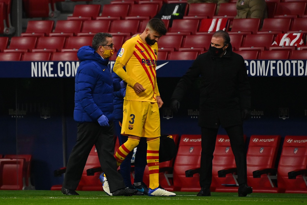 Barcelona's Spanish defender Gerard Pique (C) walks off the pitch after getting injured during the Spanish League football match between Club Atletico de Madrid and FC Barcelona at the Wanda Metropolitano stadium in Madrid on November 21, 2020. / AFP / GA